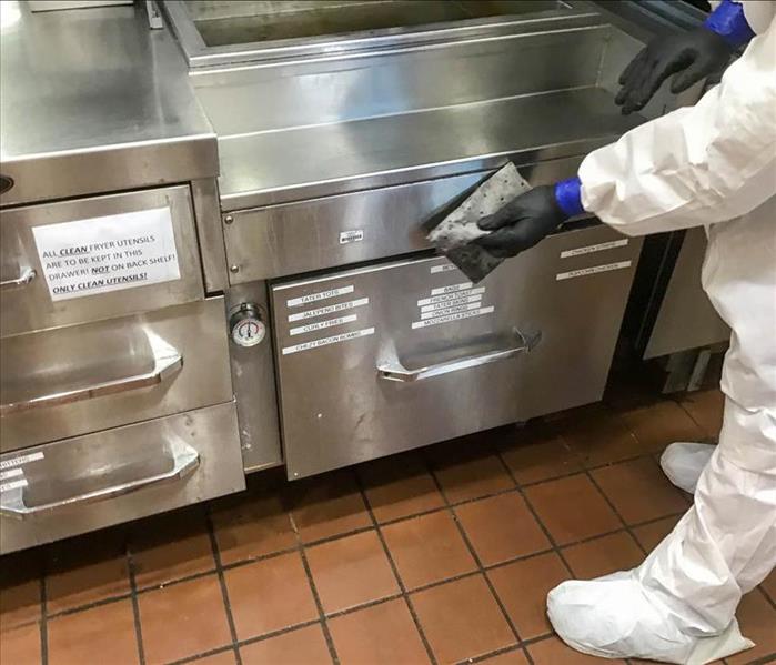 Employee cleaning kitchen. 