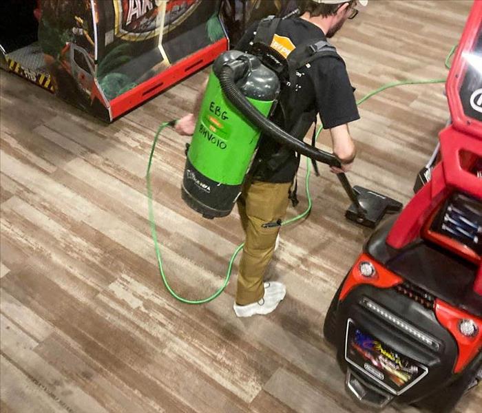Employee removes water from carpets. 